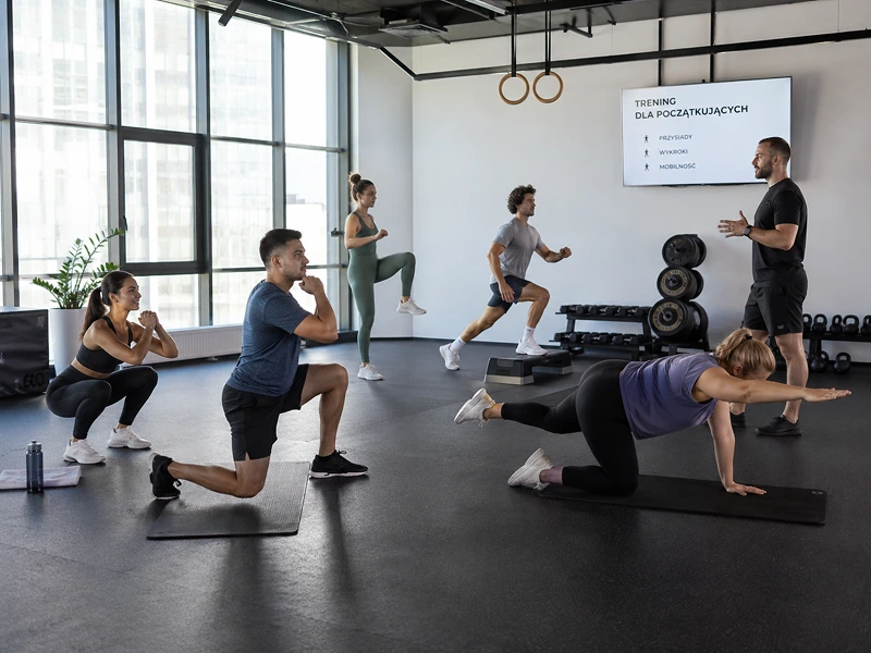Początkujący uczestnicy wykonują proste ćwiczenia fitness