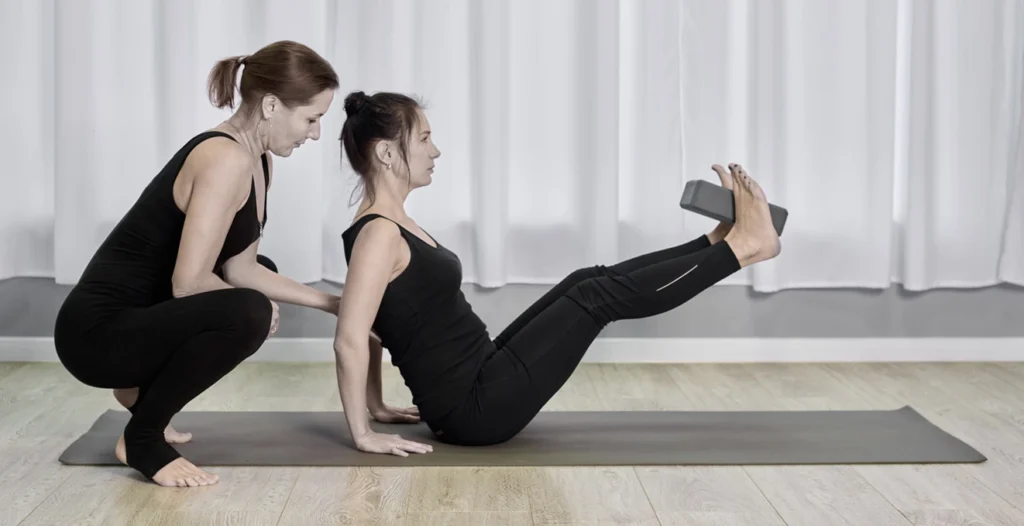 Instruktorka Pilates koryguje technikę ćwiczeń na macie